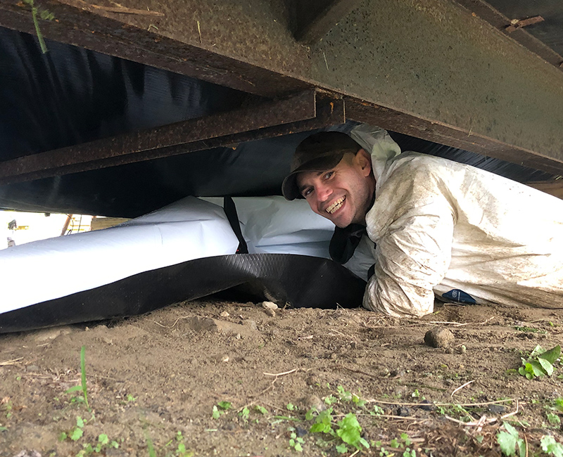 man crawling under a trailer