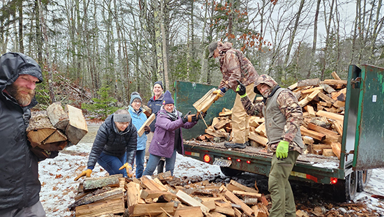 volunteers preparing a load of firewood for delivery