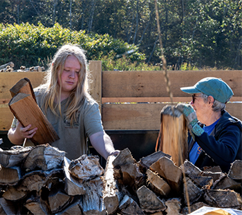 volunteers stacking firewood